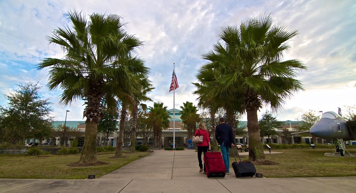 Picture of travelers with bags walking towards the Destin-Fort Walton Beach Airport terminal building